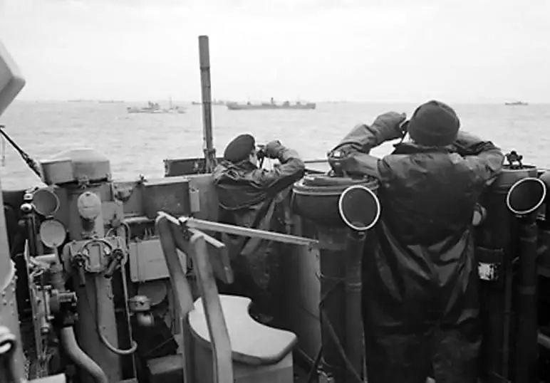 Officers on the bridge of a destroyer, escorting a large convoy of ships keep a sharp look out for attacking enemy submarines during the Battle of the Atlantic, WWII, October 1941